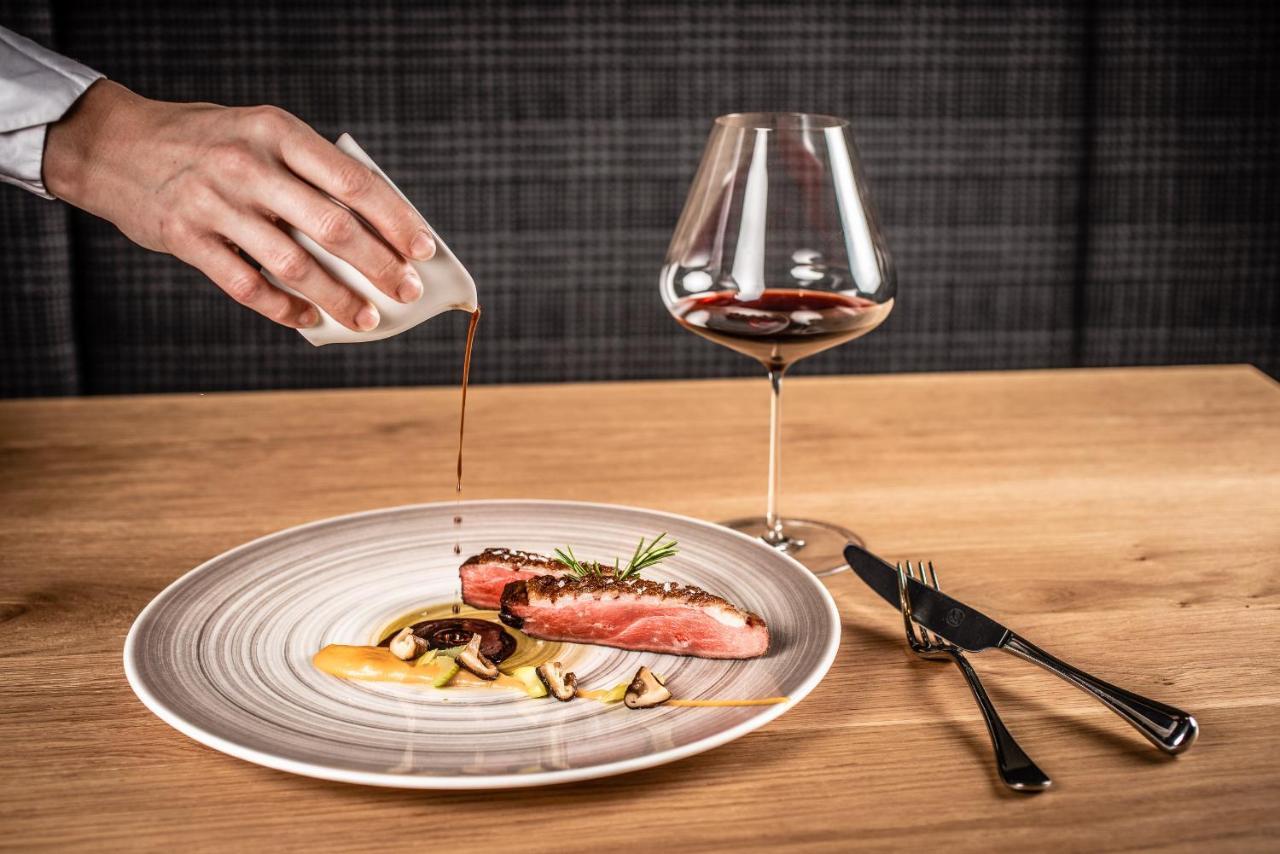 My Arbor - Dolomites Otel Bressanone Dış mekan fotoğraf A server pouring sauce onto a prepared dish
